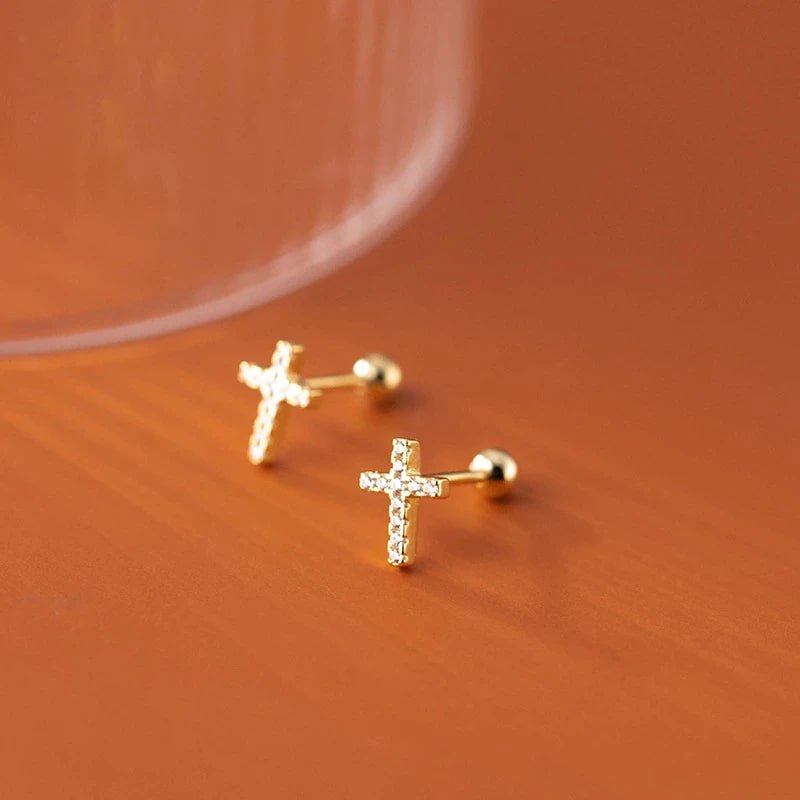 Cercei din argint cross gold pe fundal de culoare maro