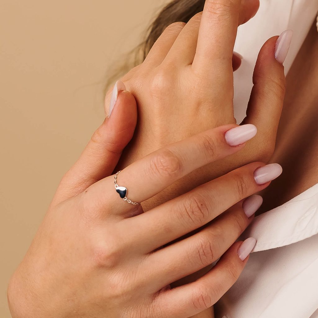 Inel din argint reglabil love pe degetul unei fete in camasa alba